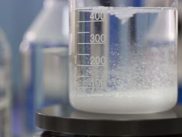 Vaso de precipitados con líquido blanco en laboratorio.