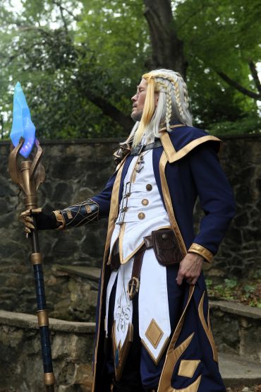 Person in detailed fantasy wizard costume holding a glowing staff.