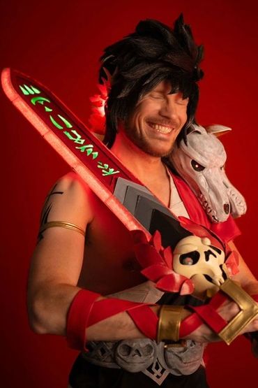 Close up of Ian laughing in the Zagreus cosplay, and the sword LEDs in full red
