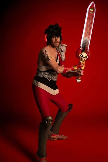 Zagreus cosplay in an action pose, featuring the shoulder tattoos and sword LEDs