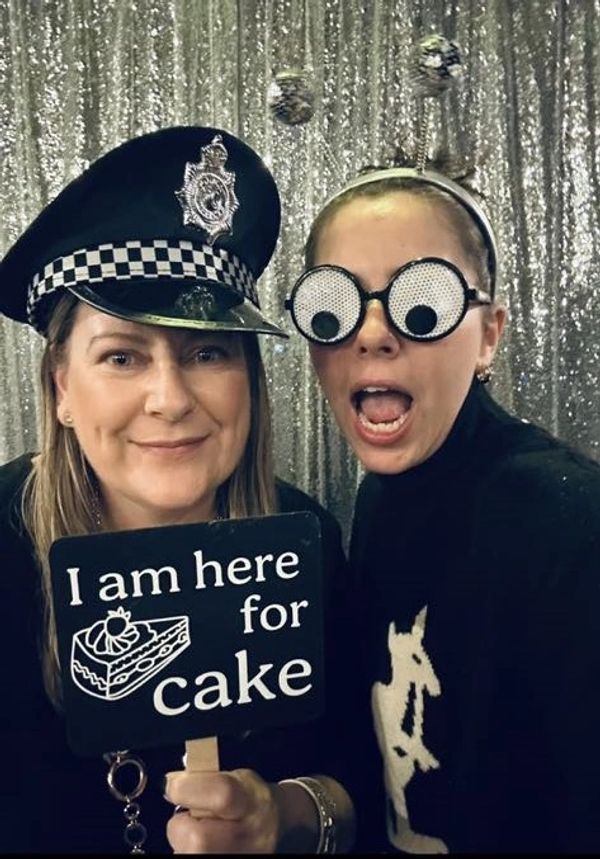 2 girls with props on at a photo booth