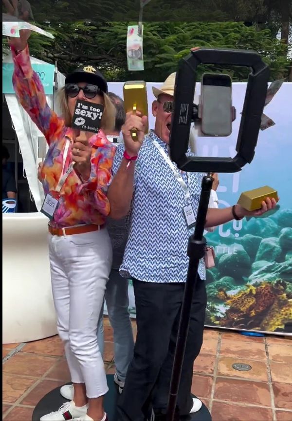 Man and lady with photo props on the 360 photo booth
