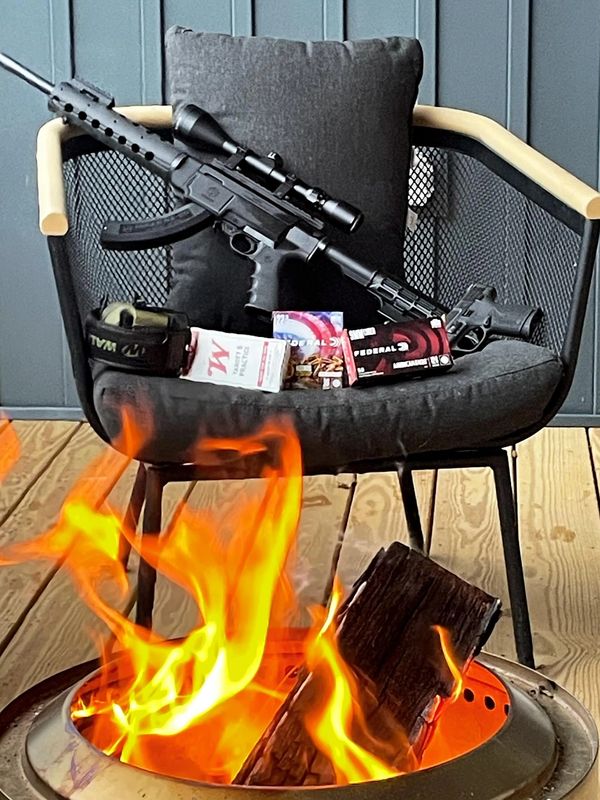 Chair on porch with fire, gun, and ammunition.