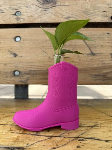 Pink Cowboy Boot Propagation Planter with a plastic test tube and green plant against wooden boards