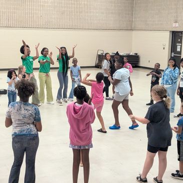 Kids playing and dancing in a circle indoors.