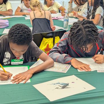 Kids focused on writing at a table.