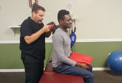 Dr. Scot providing physical therapy for his patient after the chiropractic adjustment