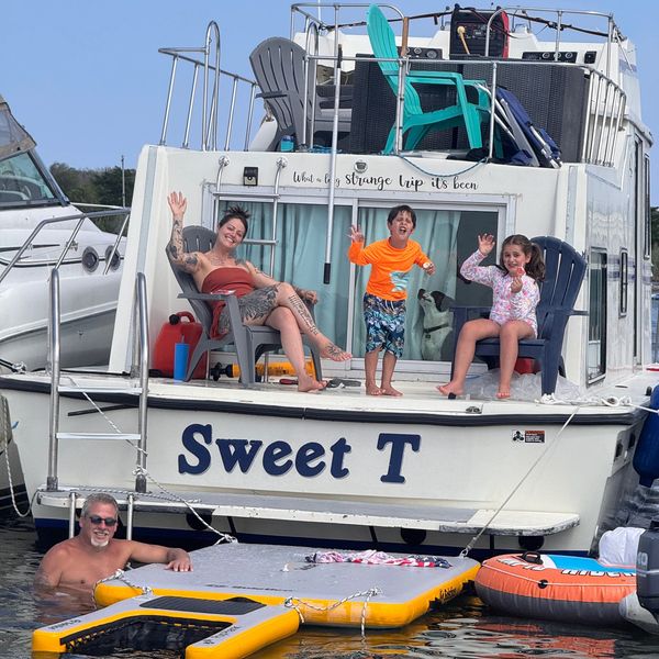 Family waving on a boat named Sweet T during a water day.