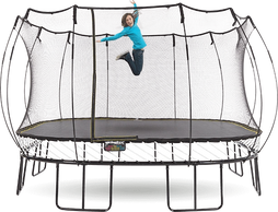 A woman in blue dress jumping on a Springfree trampoline