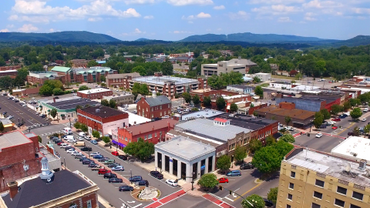 Small town downtown with historic and modern buildings under a blue sky.