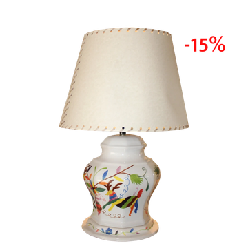 Lámpara de mesa con base de cerámica decorada y pantalla blanca.