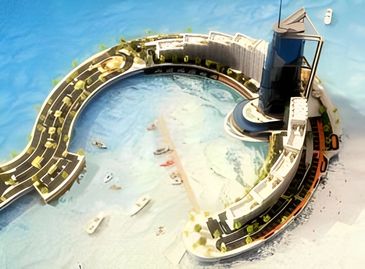 A curved, modern building complex on a waterfront, with boats in the water and a road alongside.