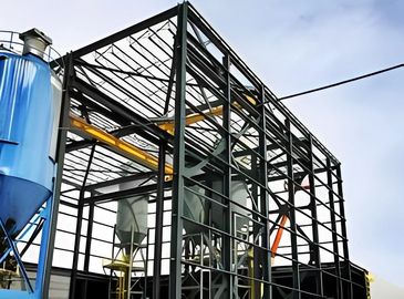 A steel skeletal structure of an industrial building with a blue silo and other machinery visible.