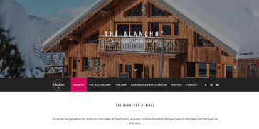 The Blanchot hotel sits warmly against a snowy mountain backdrop.