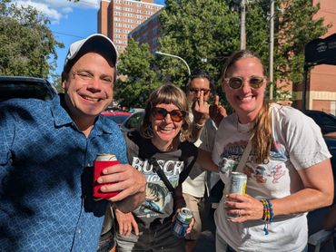 Four friends enjoying drinks outdoors on a sunny day.