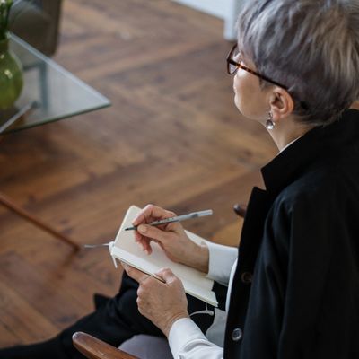 Middle aged woman taking notes while listening to a class