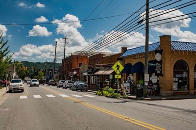 Small town main street with shops and cars under a blue sky.