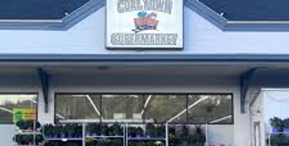 Exterior of a supermarket with a sign reading 'Gold Town Supermarket'.