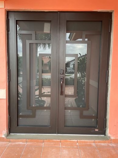 Mr Glass MG-3000 impact glass french door with design install in bronze color with grey glass.