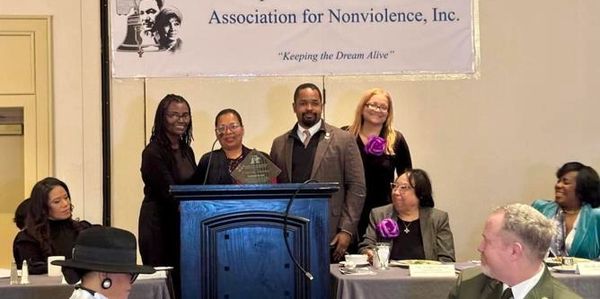 Group at Association for Nonviolence event with award.