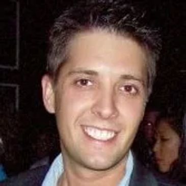 Smiling man with short dark hair.