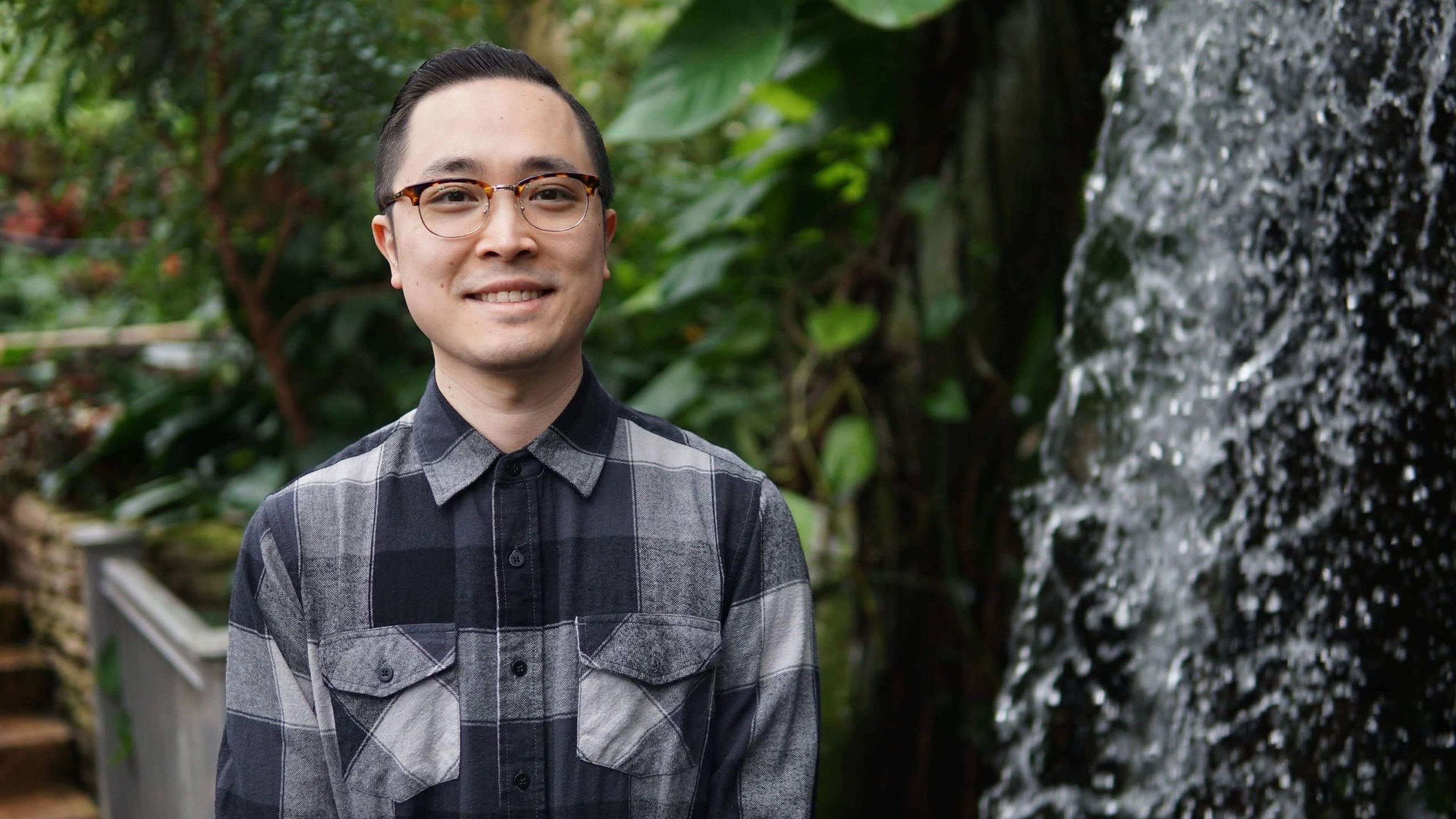 Dr. Dang smiling outdoors near waterfall