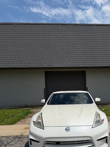 White Nissan car parked outside a building.