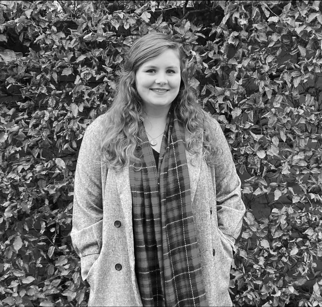 Amy from Milton Metrics, a woman in her 20s, dressed for the cold, smiling outside