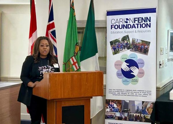 Woman speaking at a podium with health foundation banner.