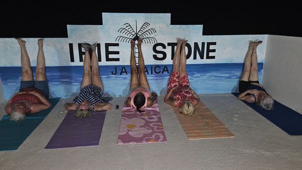 five people lying on their backs with their legs up a wall on a rooftop