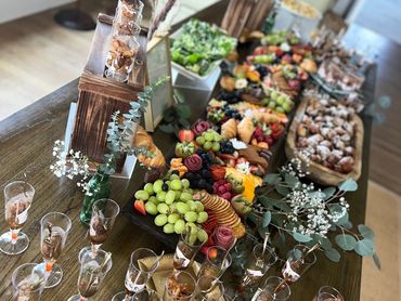 Elegant table spread with charcuterie, fruits, and appetizers in a cozy room.
