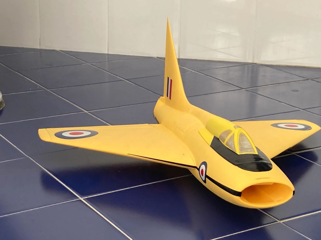 Yellow model jet with British roundels on blue tiled floor.