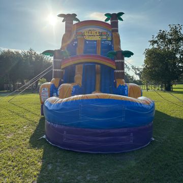 Colorful inflatable water slide set up in a sunny park.
