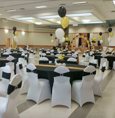Black chair bands with gold black and white balloons with white chair covers 