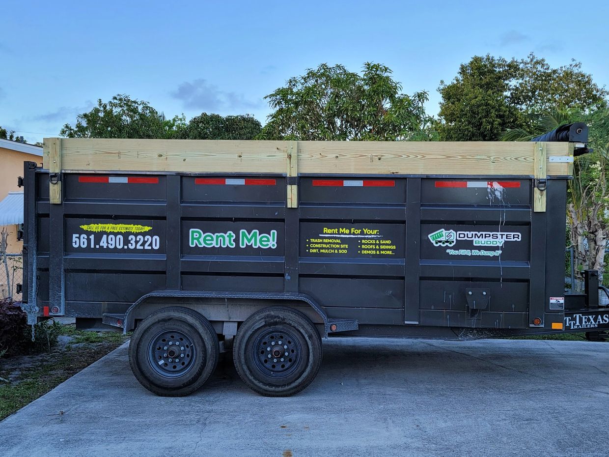 A 20 yard Dumpster parked on a driveway with contact information and rental details.