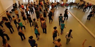 A group of people taking a dance class seen from above