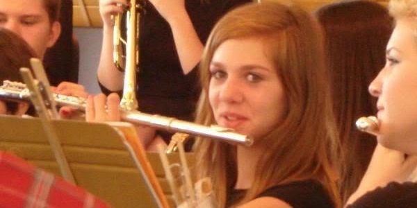 Young woman playing flute in a band.