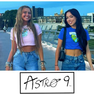 Two young women smiling on a bridge wearing Astro 9 crop tops and jeans.