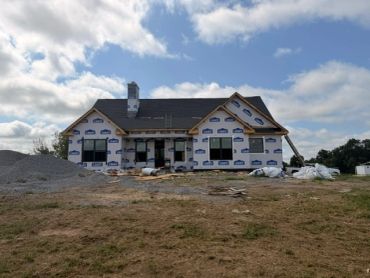 House under construction with Biden house wrap.