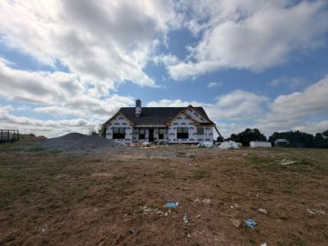 House under construction with cloudy sky.