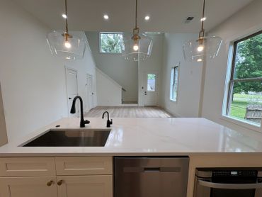 Modern minimalist kitchen with island and pendant lights.