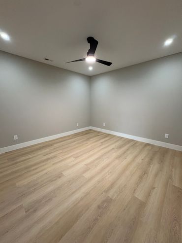 Empty room with wood floor and ceiling fan.