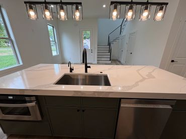 Modern kitchen island with sink and lighting.