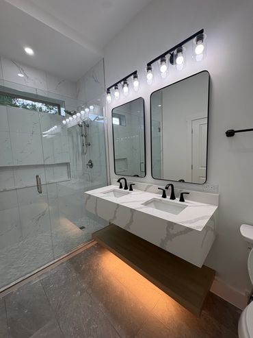 Modern bathroom with dual sinks and a walk-in shower.