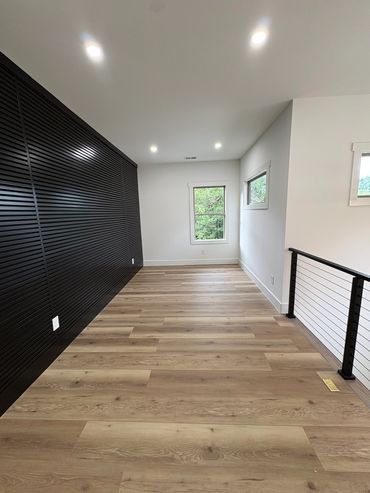 Modern room with wood floors and black slatted wall.