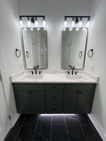 Modern double bathroom vanity with black fixtures and lighting.