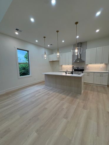 Modern kitchen with island and pendant lights.