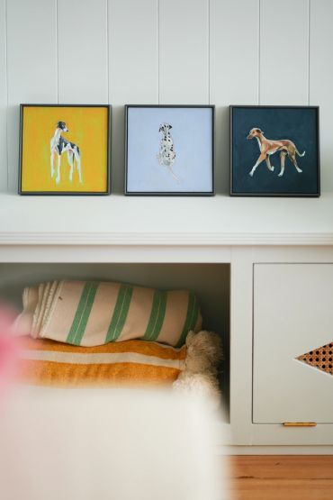 Three framed dog paintings against a wall. Animal oil paintings by Polly Pincott