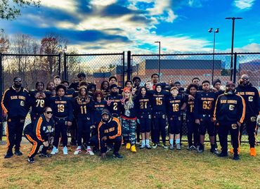 Youth football team Black Knights posing outdoors with coaches and players.