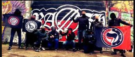 R.A.S.H. posing with street art and antifascist flags